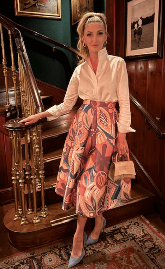 Photo of Kelly Steele posing at the bottom of a flight of stairs.